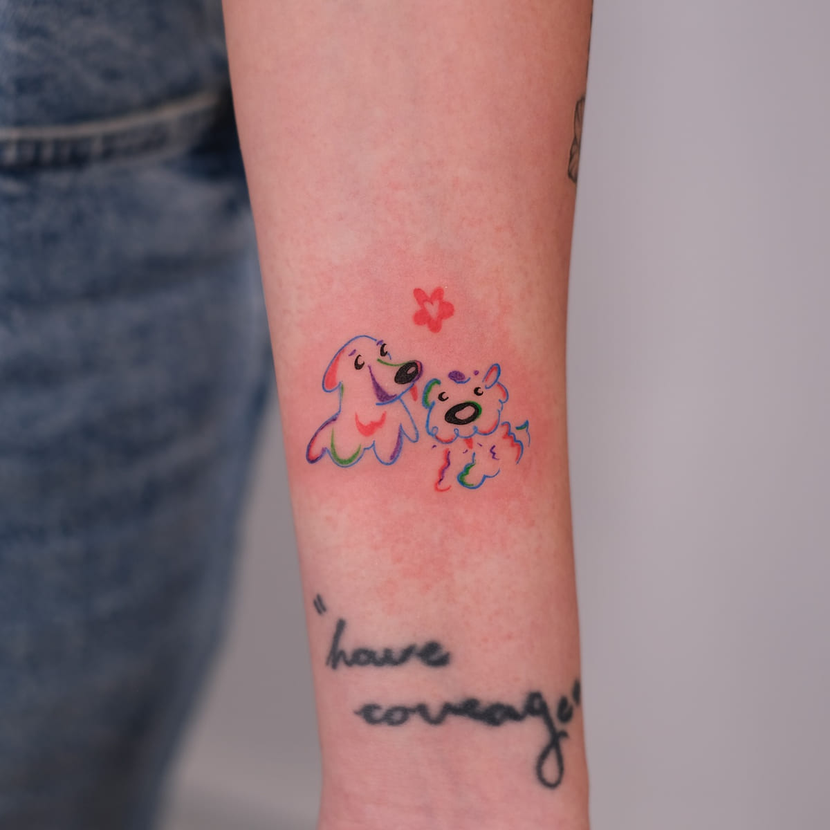 Two cartoon dogs in rainbow line with a red flower, another view
