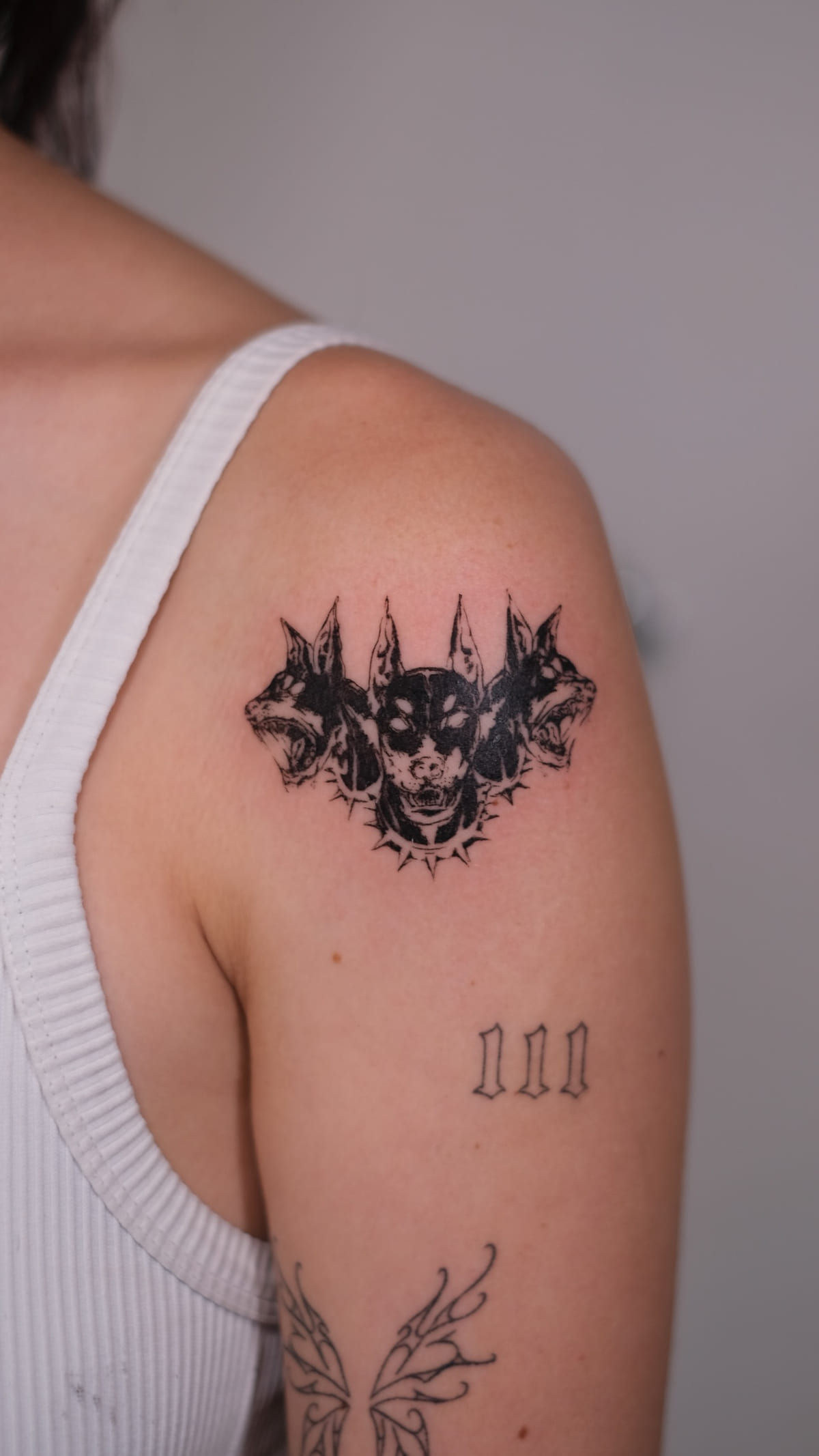 Bold black three headed dog, healed fine line tattoo, the day it was made