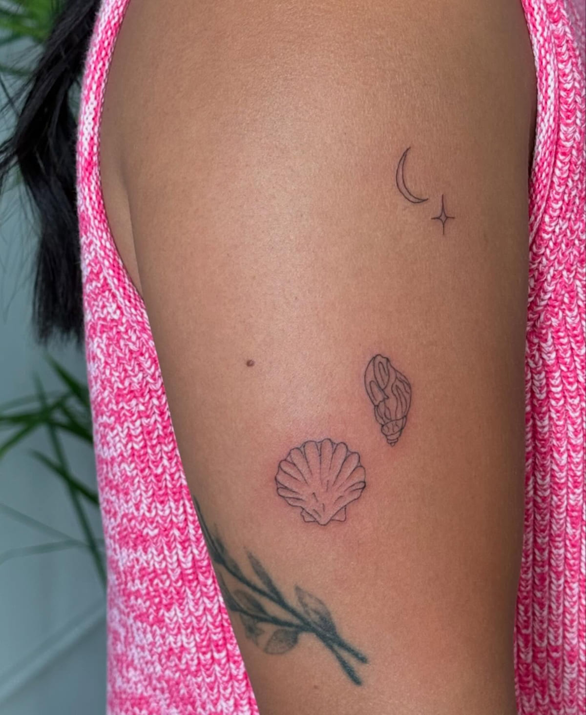 Crescent moon with a star, conch and scallop scattered on the arm, fine line tattoo