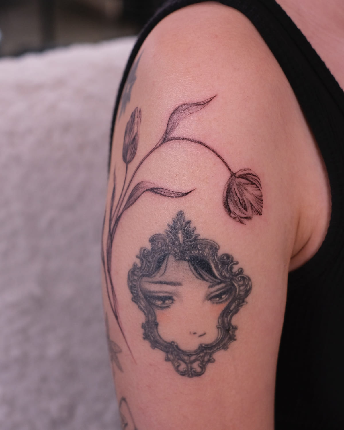 Tulips wrapping the upper arm, fine line tattoo
