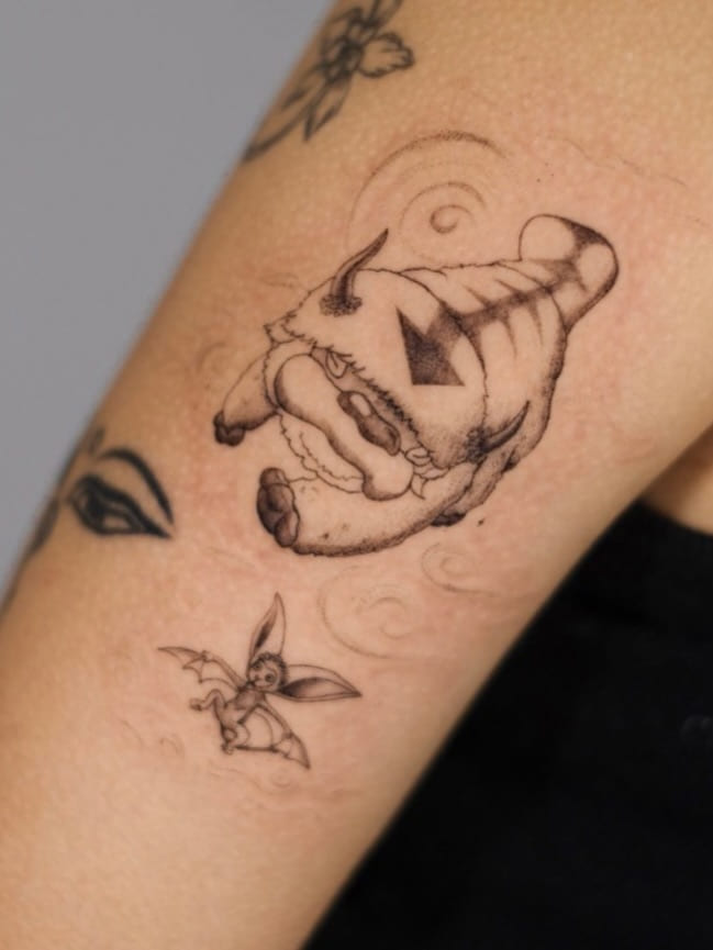 Two animated series creatures, a flying bison and a winged lemur, soft shaded with faint wind swirls, fine line tattoo