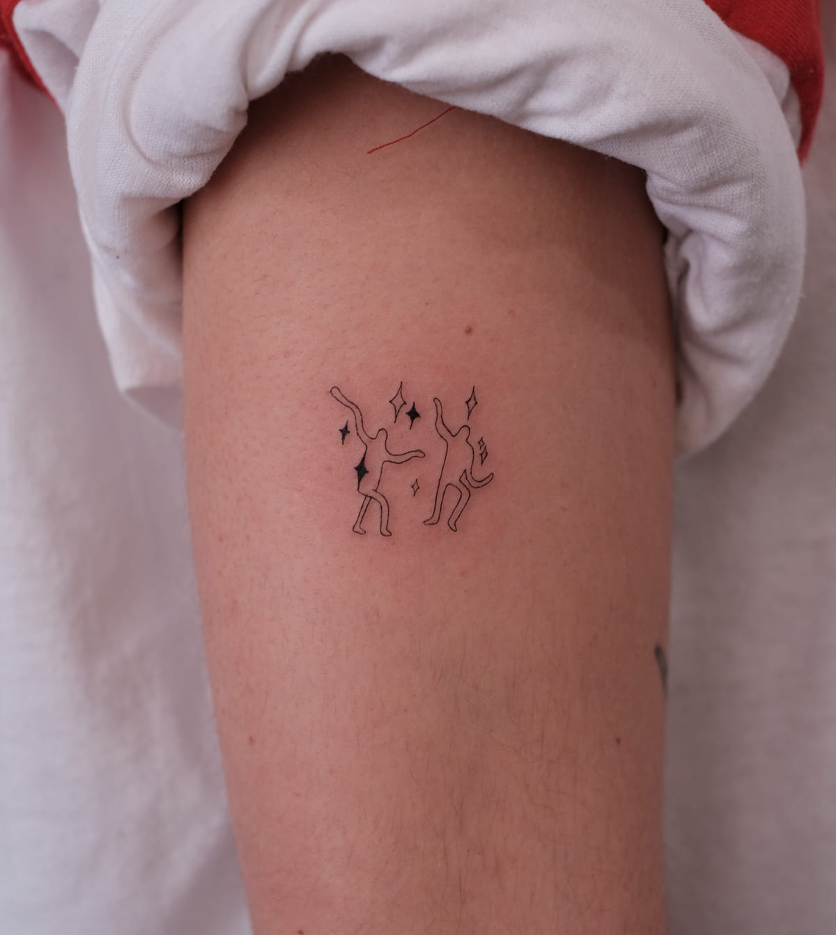 Two tiny dancing cats with sparkles, fine line tattoo