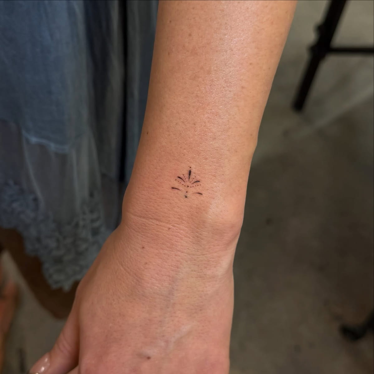 Tiny ornament of dots and a leaf, fine line tattoo