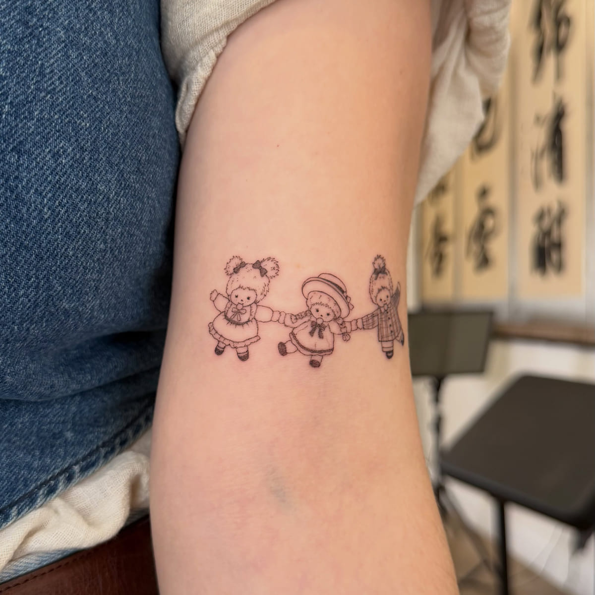 Three dressed bears holding hands, fine line tattoo