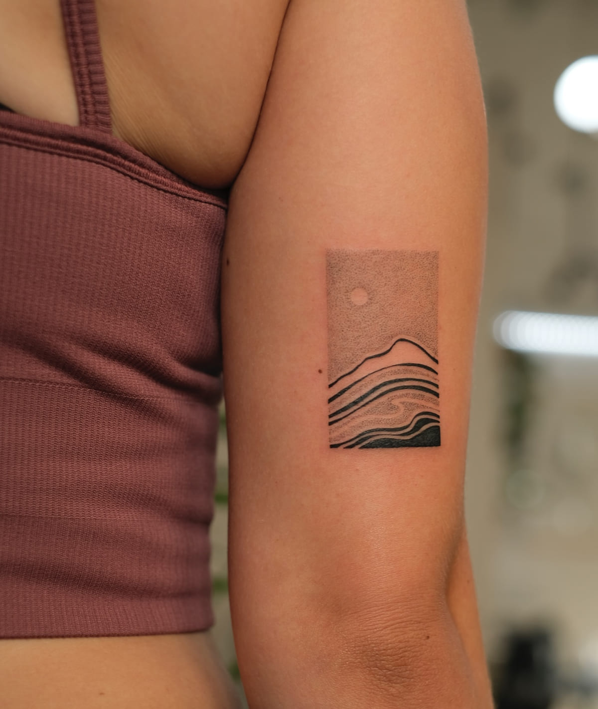 Mountain landscape in lines inside a stippled rectangle, fine line tattoo