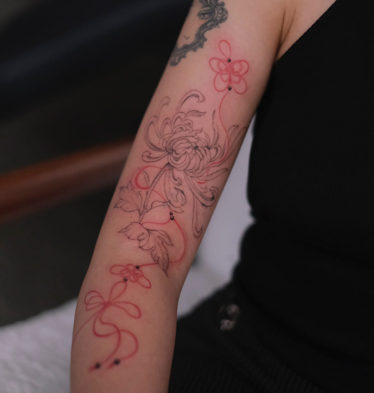 Chrysanthemum and flowers tied with red bows, running down the arm, another view