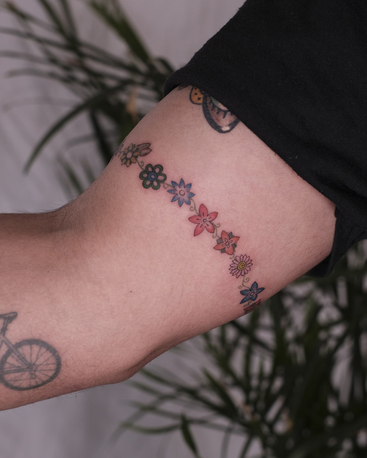 Armband of flowers in many colors, fine line tattoo