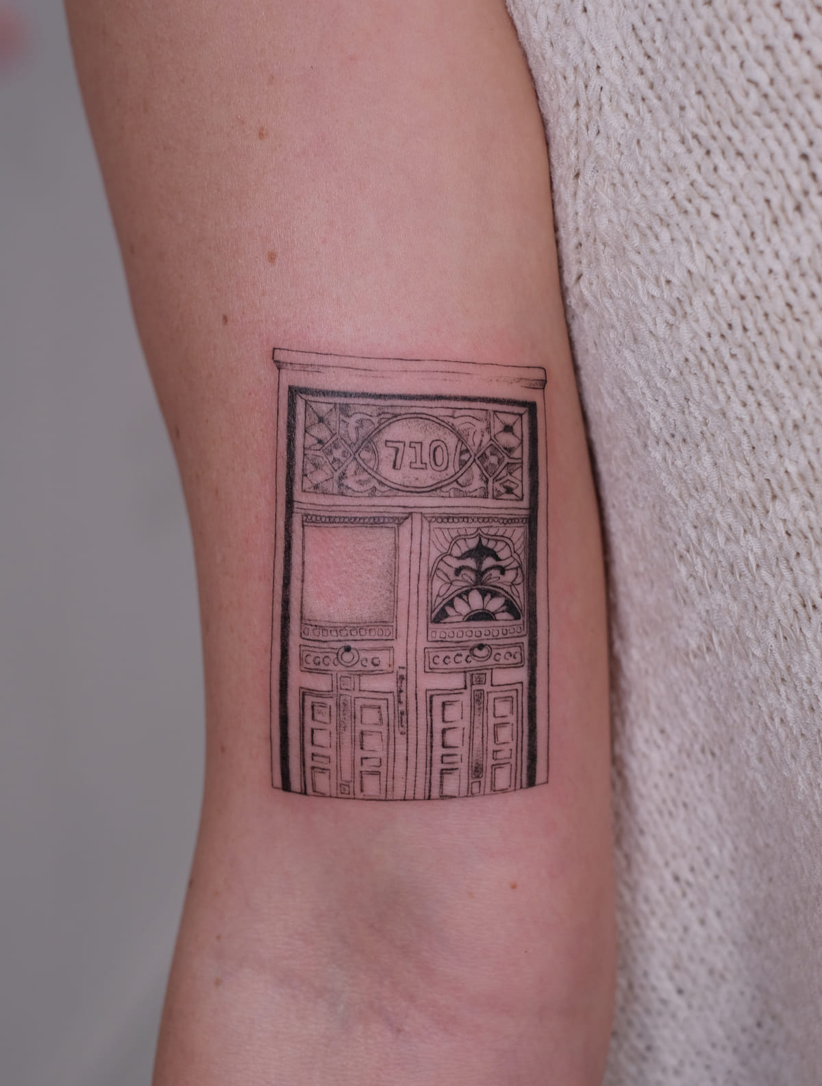 Ornate Victorian door numbered 710, fine line tattoo
