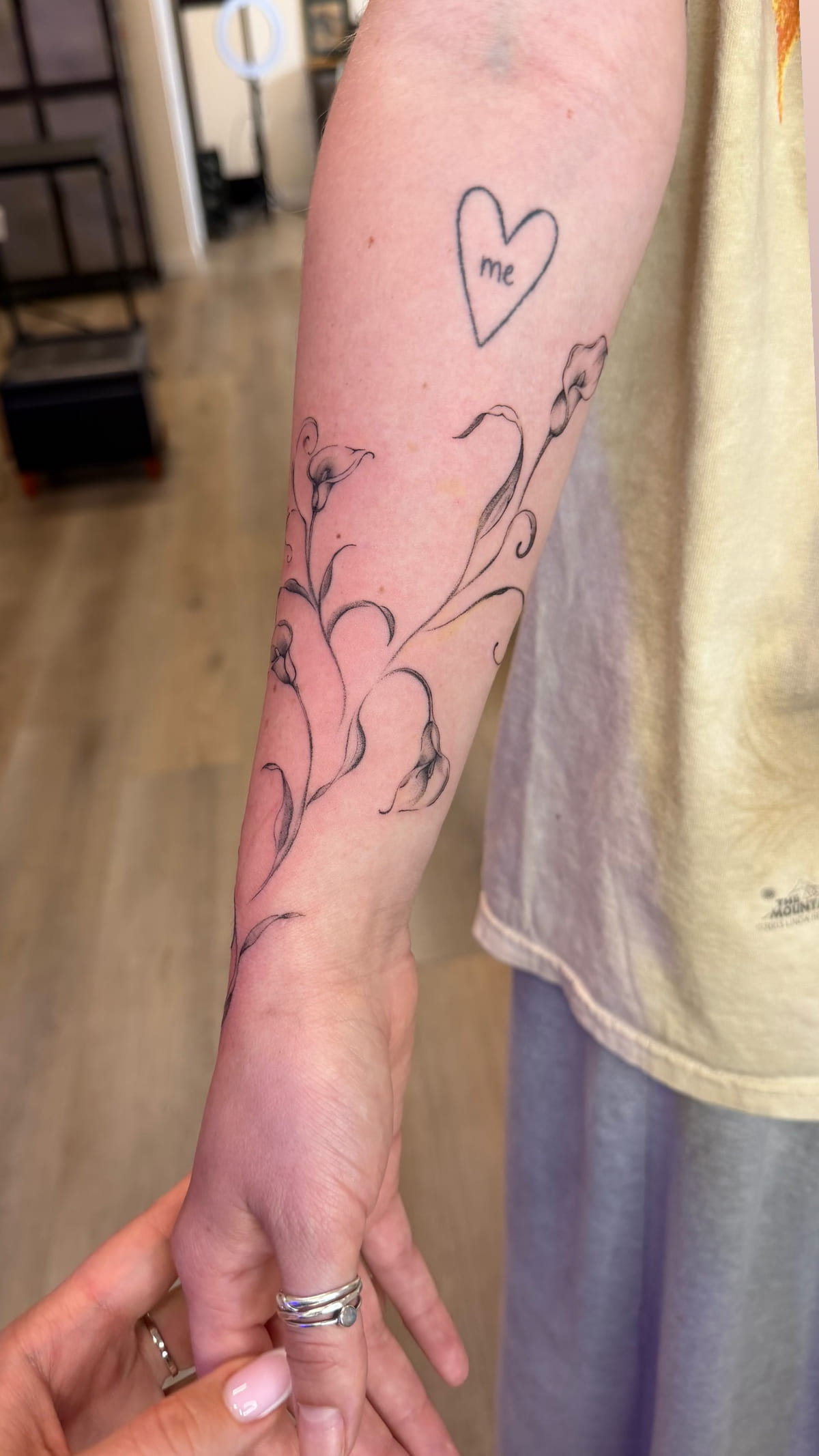 Calla lilies running from forearm onto the hand, healed fine line tattoo, the day it was made