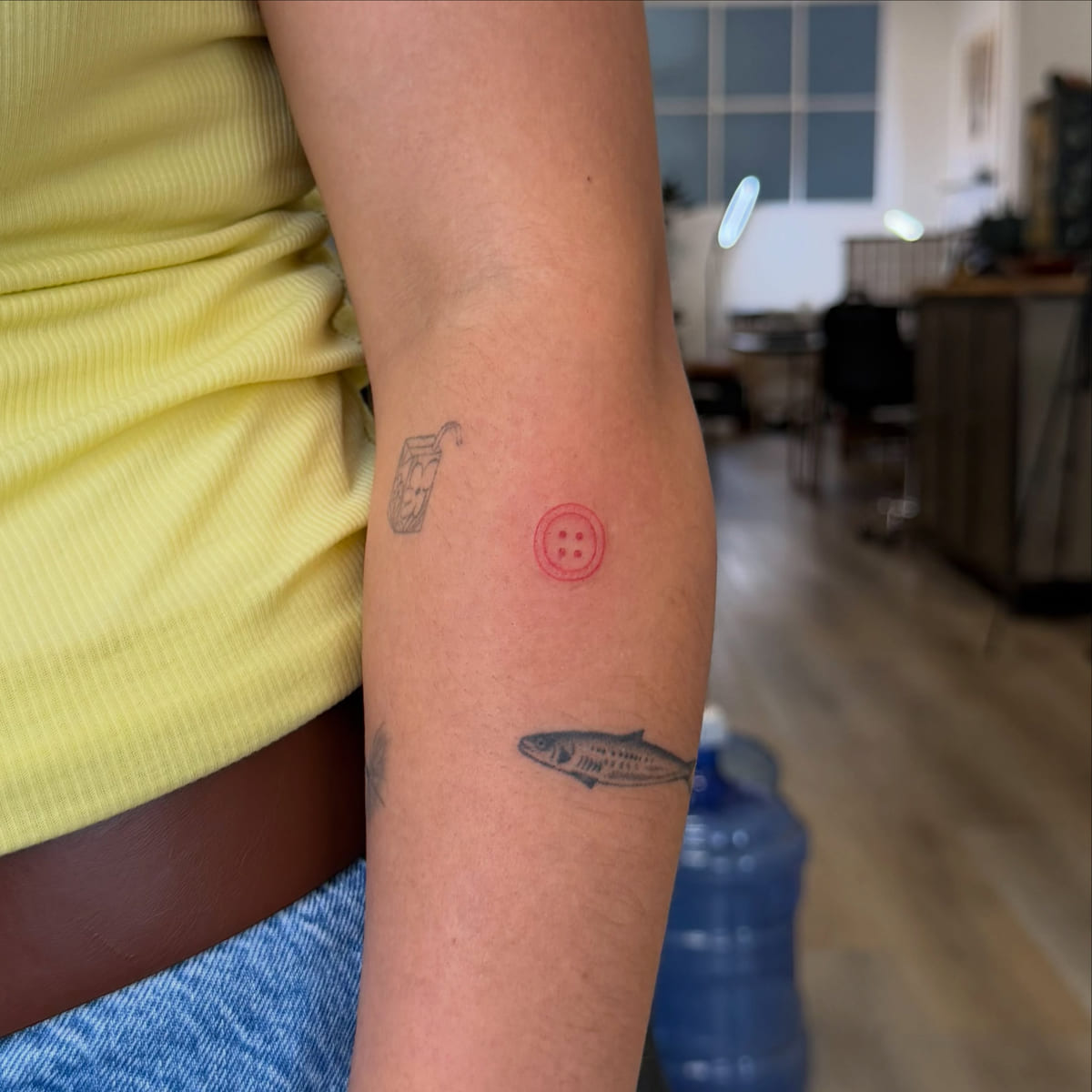 Red button, fine line tattoo