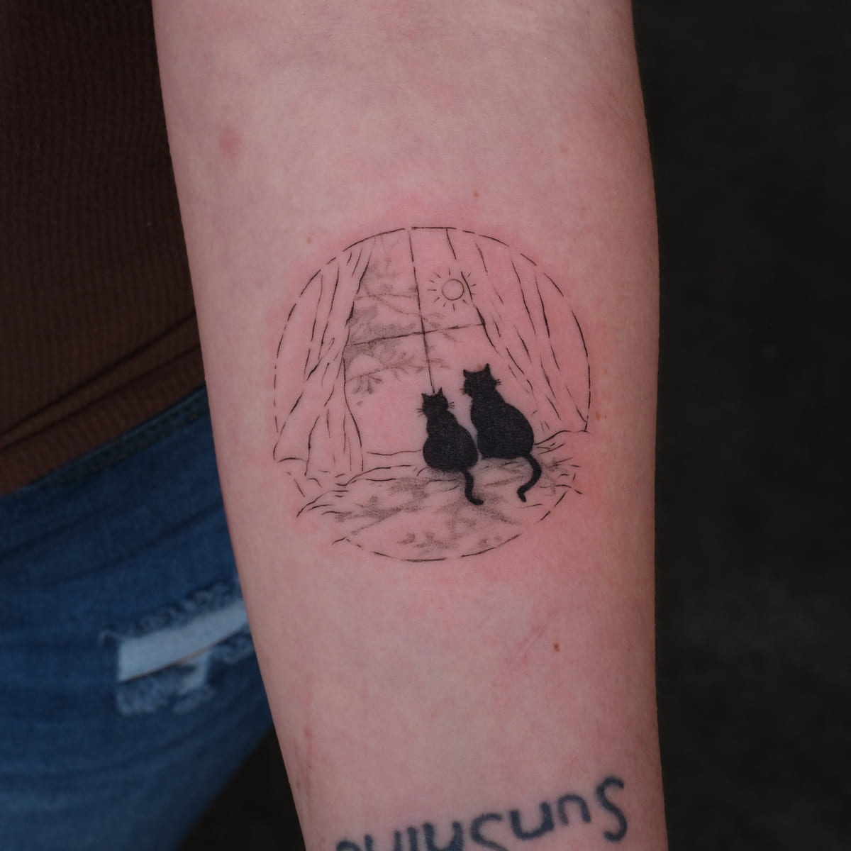 Two black cats at a curtained window, round frame, fine line tattoo