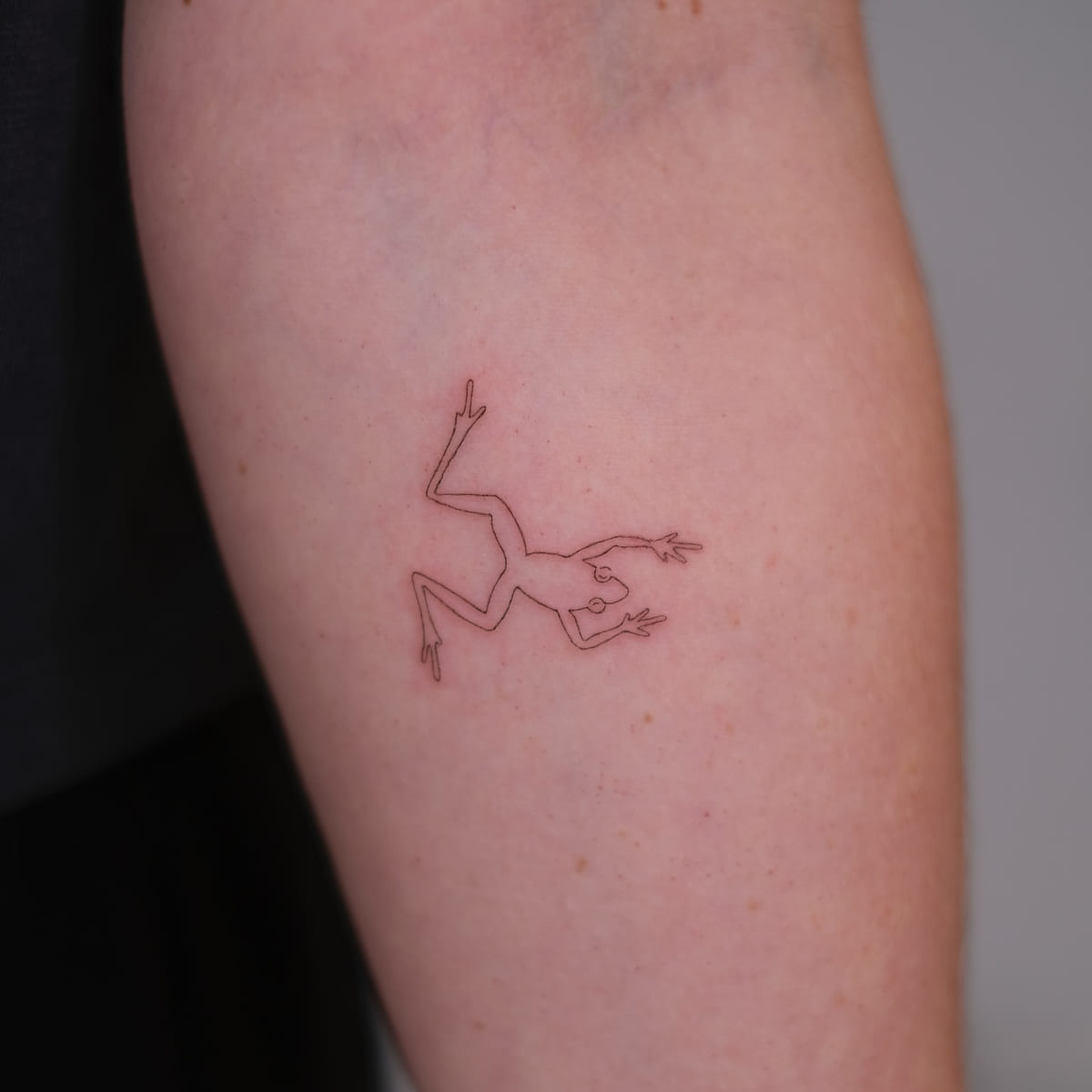 Leaping frog in fine red line, fine line tattoo