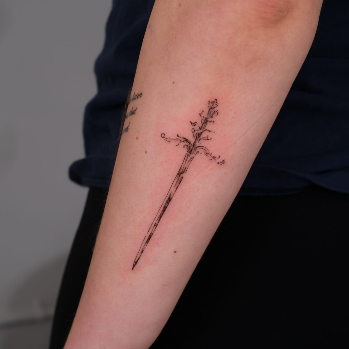 Ornamental dagger with flowers, fine line tattoo