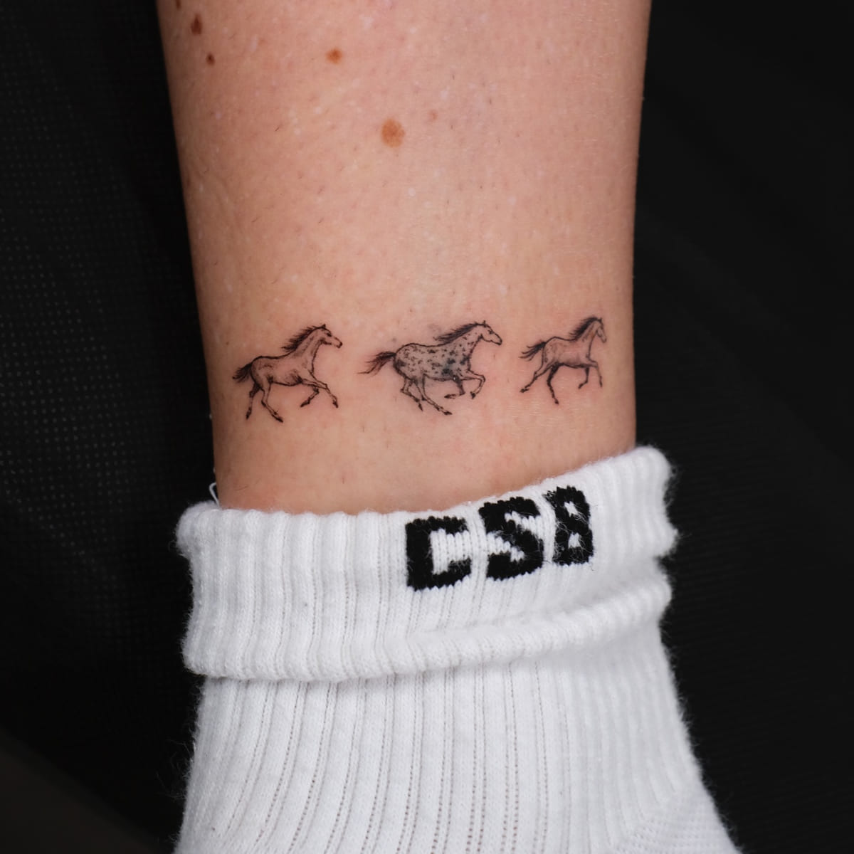 Three tiny running horses, fine line tattoo