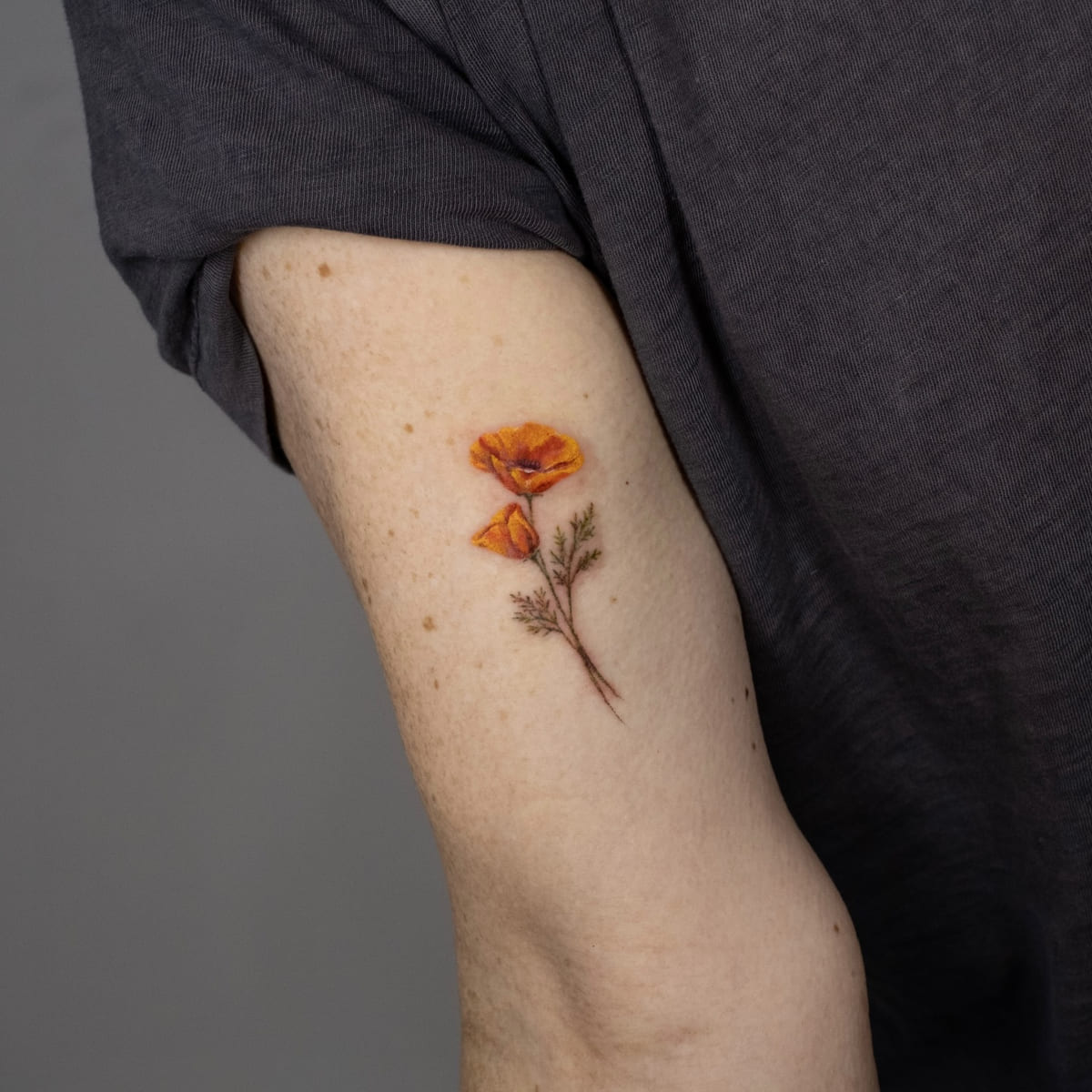 California poppy in color, fine line tattoo
