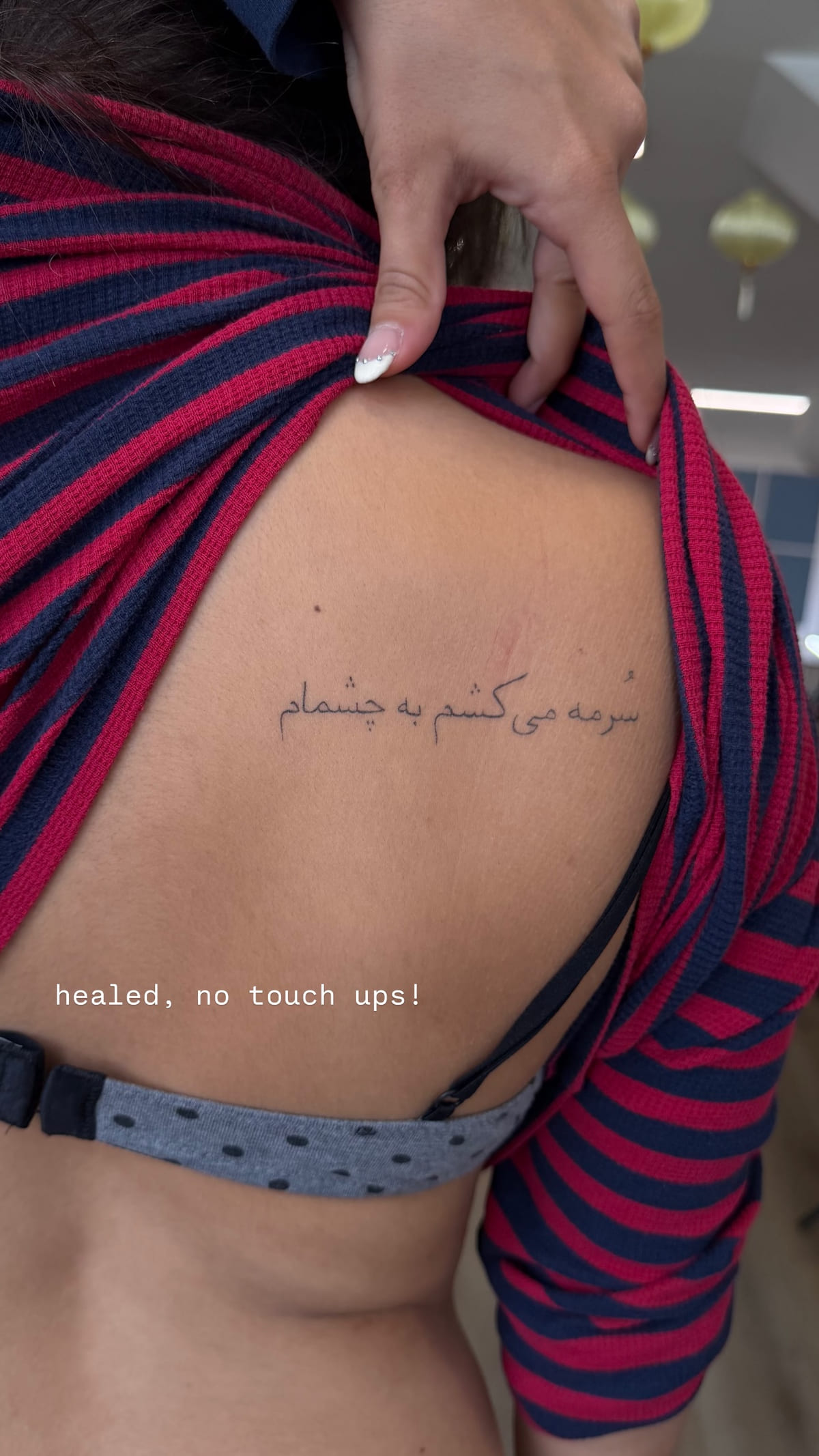 Line of Persian script on the ribs, healed fine line tattoo