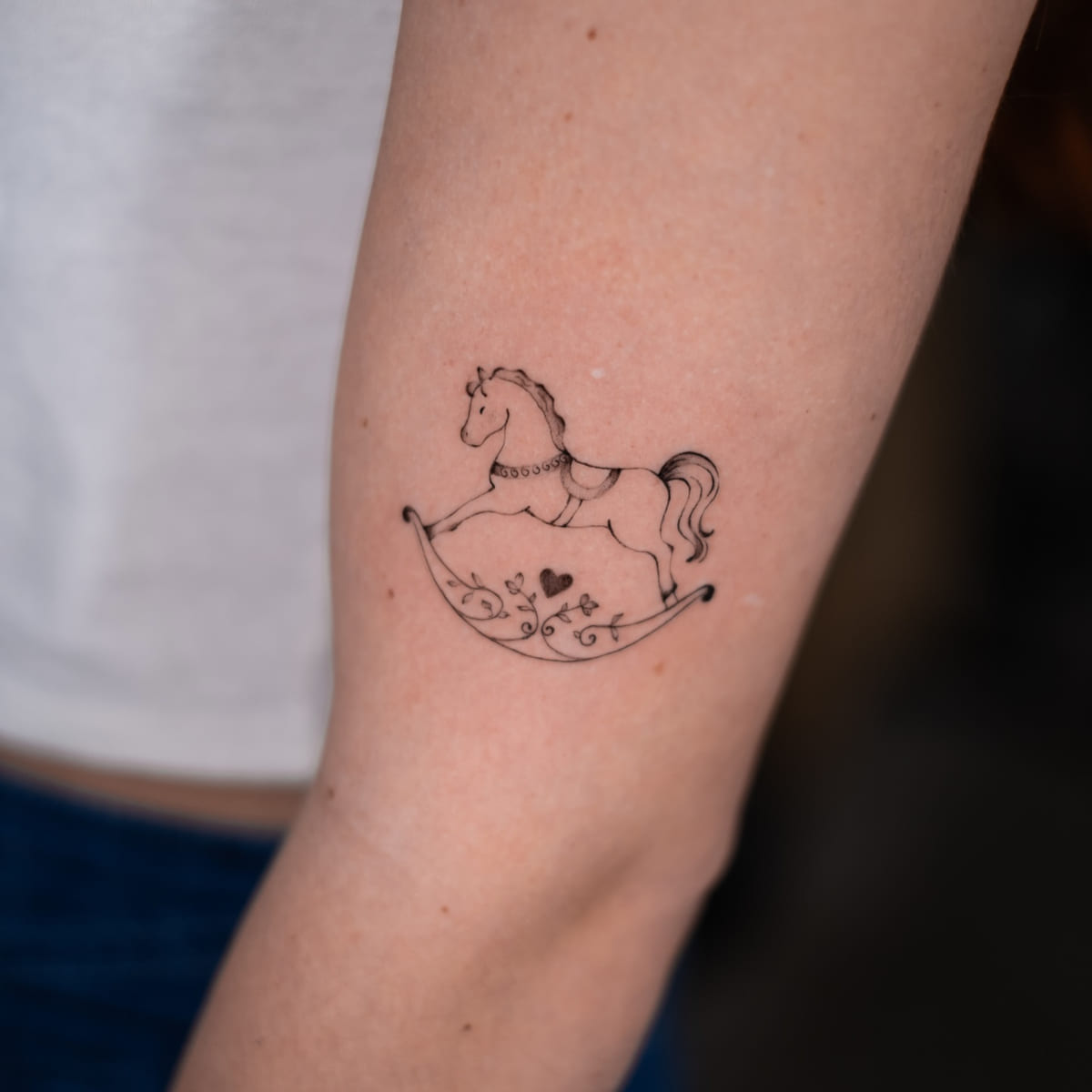 Rocking horse with a heart, fine line tattoo